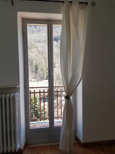 普拉吉拉托Hostsrevolution Pragelato的窗户配有窗帘,享有阳台的景致。