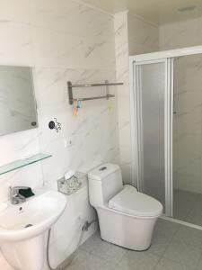 白沙乡喵喵鱼客舍的白色的浴室设有卫生间和水槽。