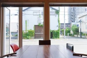 札幌BEACH AND FIELD INN的一间会议室,配有桌椅和窗户