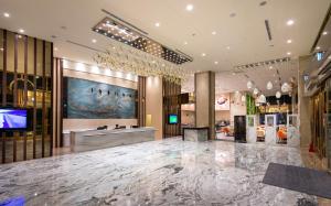 台东禾风新栈度假饭店的大堂设有大型大理石地板和电视。