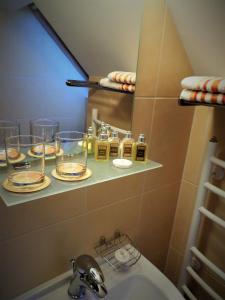 帕兰加Vila Claudia的浴室位于水槽上方的架子上方,配有玻璃杯