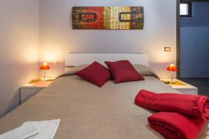 庞贝生态住宿加早餐酒店的一间卧室配有一张带红色枕头的大床
