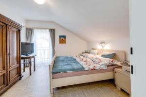 玛利亚采尔Gerli Appartement Mariazell的一间卧室配有一张床,并在一间客房内配有电视。