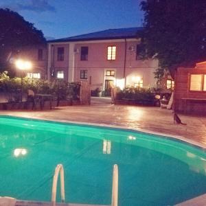 廖内罗因武尔图雷Country House Villa delle Rose Agriturismo的夜间在房子前面的游泳池