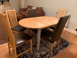 圣奥尔本斯Spacious 3 Bedroom Apartment的一张带四把椅子的木桌和一间客厅