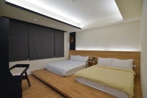 台东水菓糖民宿的一间卧室设有两张床和大窗户