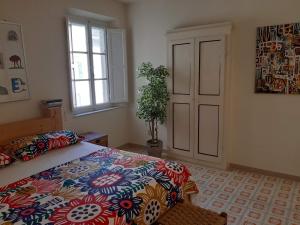 比萨Francesca House的一间卧室配有一张带彩色床罩和窗户的床。