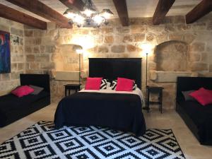 MġarrTa Skorba Farmhouse Mgarr的一间卧室配有一张带红色枕头的大床