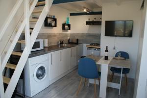 Pujols GirondeMARIBEN的厨房配有洗衣机和桌椅