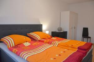 巴特Ferienhaus Leonie的床上有两个橙色枕头