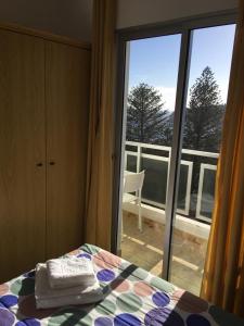 圣地亚哥海滩Apartamentos Noda的一间卧室设有一张床,享有阳台的景色