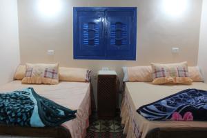 法尤姆Tunis Village Chalet的两张睡床彼此相邻,位于一个房间里