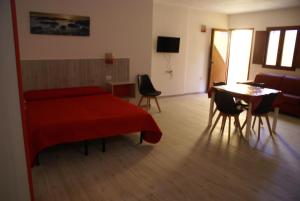 卡拉古诺内casa mariolu 2的一间卧室配有红色的床和桌椅