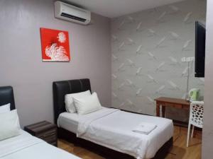 甲抛峇底卡米利亚酒店的酒店客房配有两张床和一张书桌