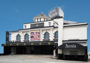 尼崎市Xenia Amagasaki的白色的建筑,上面有标志