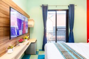 北榄Lilliput Riverside Bangkachao的一间酒店客房,配有一张床和一台电视