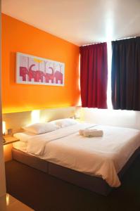 Padang EndauHotel Jeti Tg Gemok的一间卧室配有一张带橙色墙壁的大床