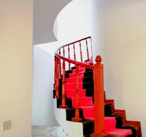 齐克拉约Santa Victoria House的白色墙壁的房间里,红色的楼梯