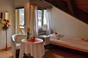 Embrach弗雷霍夫恩布拉赫住宿加早餐旅馆的一间卧室配有一张床、一张桌子和一个窗户。