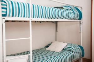 托雷坎内Case Vacanza Torre Canne的双层床,配有蓝色和白色条纹床单