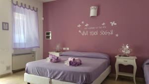 奥斯图尼玛格丽特住宿加早餐酒店的一间卧室设有两张单人床和紫色墙壁