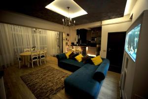 布拉索夫Classic Apartment的客厅配有蓝色的沙发和电视