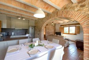 圣科洛马·德法尔Can Jan de Castanyet的一间带白色桌子的用餐室和一间厨房