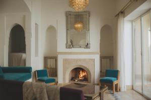 马拉喀什杜克斯图尔斯酒店的客厅设有壁炉和蓝色椅子