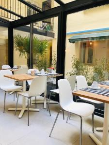巴黎马莫泰星晨酒店的用餐室配有桌子和白色椅子