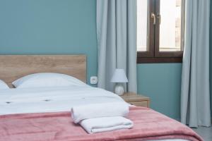 海若克利欧Comfy & Modern Apartment in the Heart of Heraklion的一间卧室配有一张床,上面有两条毛巾