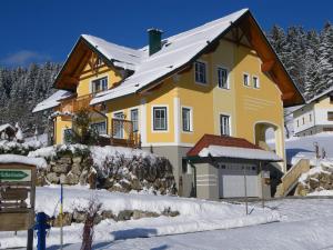 拉肯霍夫奥夏泰福民宿的一座黄色房子,屋顶雪盖