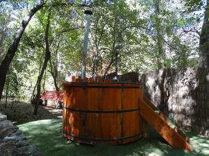 圣何塞德迈波Cabañas Alegria Cajón del Maipo的公园里的木桶,有栅栏和树木