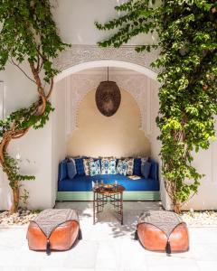 马拉喀什里亚德伊德拉酒店的客厅配有蓝色的沙发和桌子