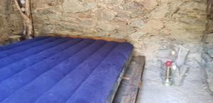 Santa-Lucia-di-MercurioU paliaghju, une cabane de berger pour vivre un dépaysement total的石墙洞内的一张蓝色的床