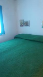 CannoleLa municeddha的一间卧室配有绿色的床单