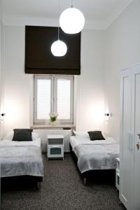 卢布林Rodmos Hostel的一间卧室设有两张床和窗户。