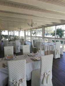 科隆内拉Le camere di Villa Incanto的一间设有白色桌椅和窗户的用餐室