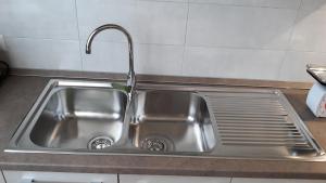 BussoLux Appartamento的厨房里带水龙头的不锈钢水槽