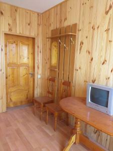 卡罗利诺-布加兹Бирюза的木墙上的房间,配有桌子和电视
