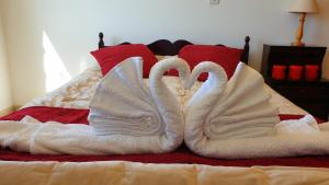 Ayia MarinaAstrofegia Apartments Near The Sea的两个天鹅,被毛巾包在床上