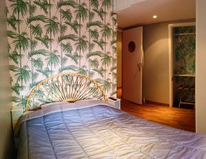 尼斯梅耶皮尔沙滩酒店的一间卧室配有一张棕榈壁纸床