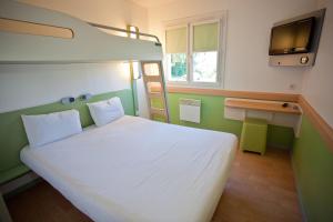 圣蒂博德维涅马恩河谷宜必思快捷酒店的卧室配有白色的床和电视
