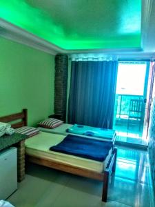 马塞约Recanto do Mergulhão的一间卧室配有一张绿灯大床