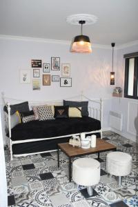 Annet-sur-Marnele petit boudoir的客厅配有黑色沙发和桌子