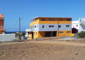 TarrafalCasa Patio的一条土路旁的黄白色建筑