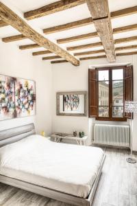 基安蒂格雷夫Il Nido nel Chianti的白色的卧室设有一张大床和一个窗户