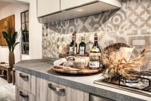 基安蒂格雷夫Il Nido nel Chianti的厨房柜台上的酒瓶和面包托盘