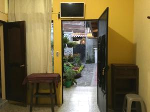 圣地亚哥阿蒂特兰Casa Josefa Hotel的通往走廊的开放式门,走廊上设有桌子和凳子