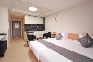 巨济Geoje Leein Stay Hotel的酒店客房带一张床和一个厨房