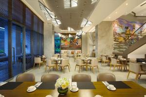 雅加达Ascott Sudirman Jakarta的餐厅内带桌椅的用餐室